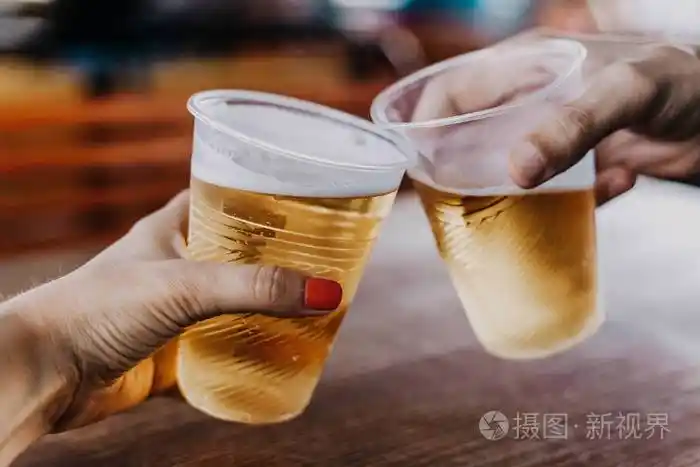 啤酒预约一只手和一个修指甲的女人握着一个塑料玻璃杯男汉第二杯