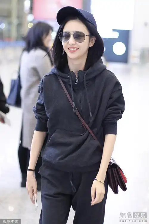 佟丽娅运动装现身机场 托腮微笑露虎牙超可爱