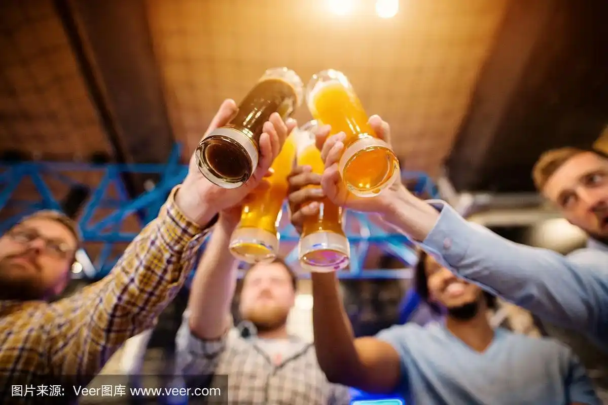 当四个男性朋友在酒吧碰杯的时候,啤杯的底部视图.