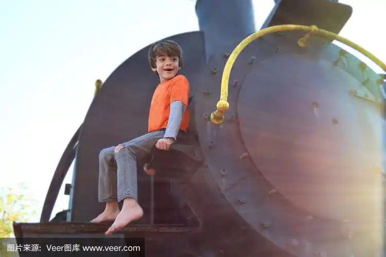 光着脚的男孩高高地坐在火车上