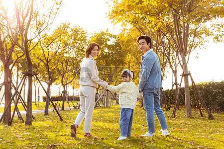 牵手妈妈一家三口草地散步背影背景