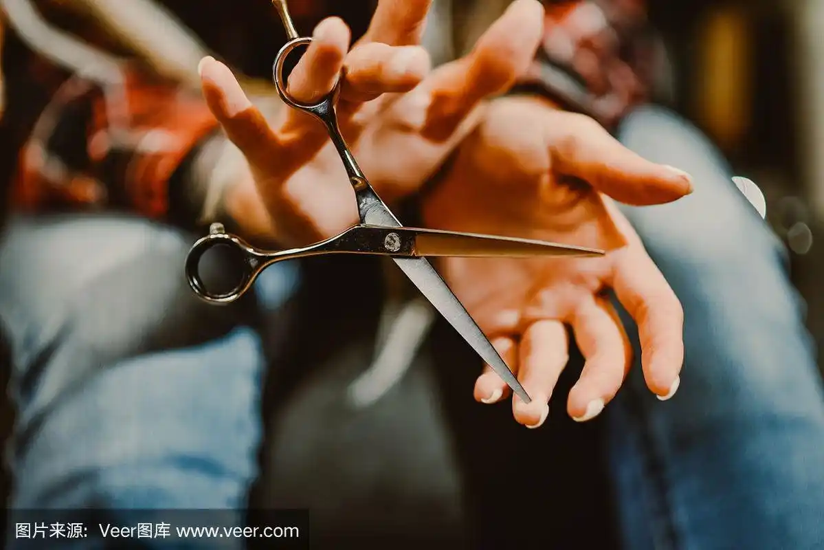 女孩发型师手握剪刀剪头发特写