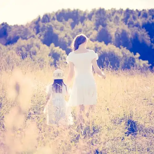 母亲和女儿在草地上散步