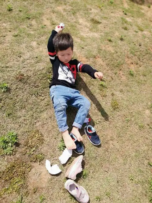 孩子们估计是担心老师会批评他们,连忙将自己的小鞋子和袜子套在自己