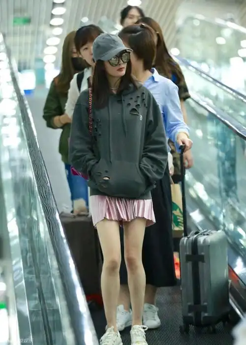 杨幂冒寒风穿粉红短裙 美腿吸睛坐姿少女