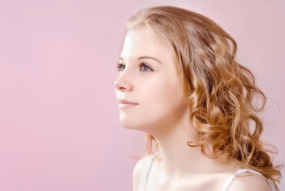 粉色背景美丽青春活泼的金发侧脸女孩鼻子整形美女三七女生节37女生节