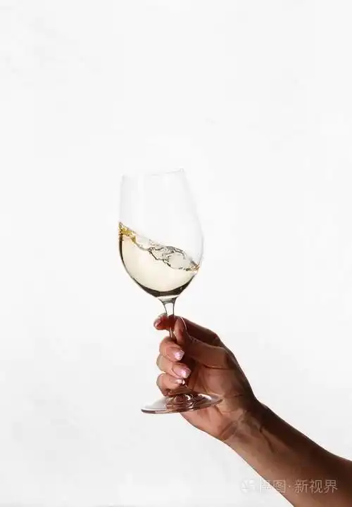 手握一杯白葡萄酒