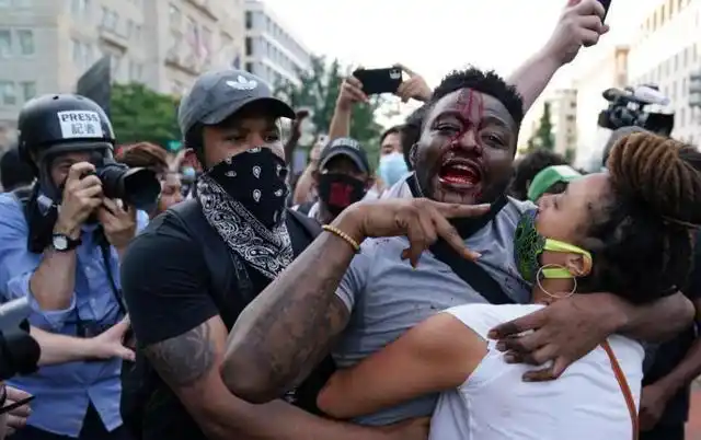 这可并非是个例,在洛杉矶街头,一名黑人女子示威群众看见几个暴徒在