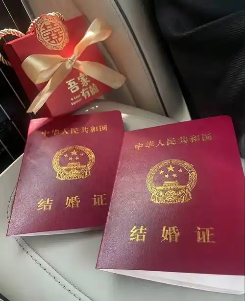 两人把结婚证件照放在了车座椅上,椅背上还放着喜糖盒子,画面十分喜庆