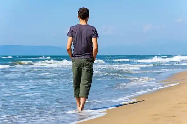 男子海边走背影