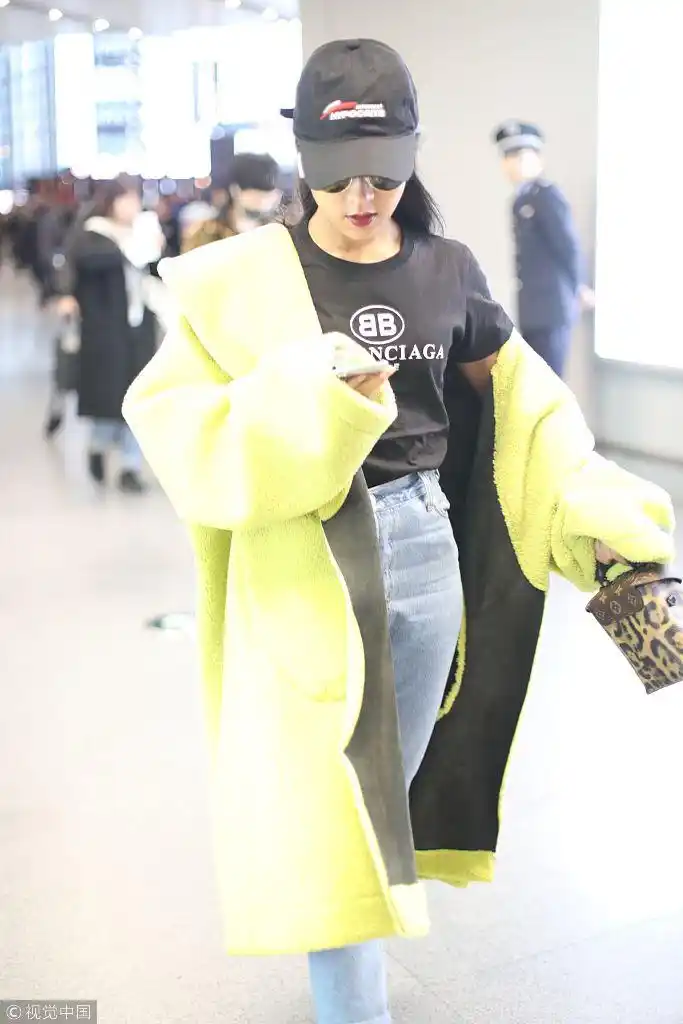 吉克隽逸黄色外套半脱潮范十足 踩细高跟玩手机气定神闲