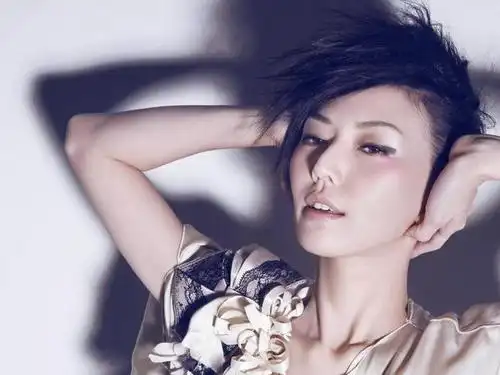 照片中孙燕姿穿着一套水蓝色民族风服装,双马尾,搭配同色系的发带