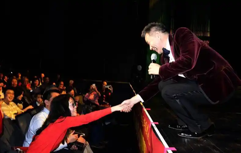 华人喜爱的男高音歌唱家王宏伟在演唱中与观众互动致意  (图为张大卫