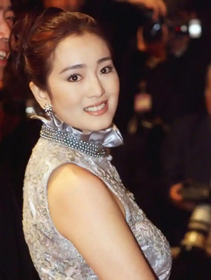 巩俐的侧颜硬照展示出一种独特的美,虽然鼻梁不高且有双下巴,但依然能