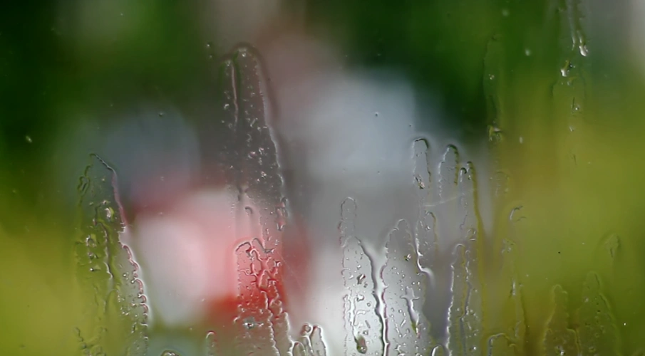 玻璃窗户上雨滴划落模糊效果高清雨天实拍视频素材