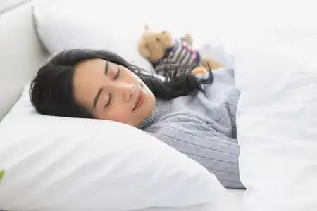 侧卧亚洲女人侧卧在卧室的床上照片