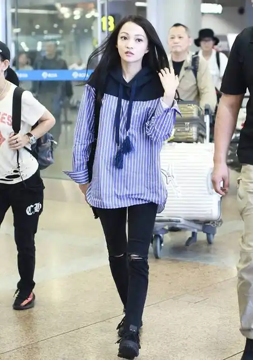 张韶涵现身机场穿拼接条纹卫衣配破洞牛仔裤双腿纤细抢镜