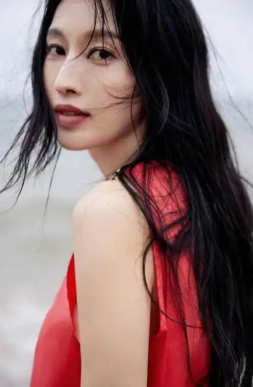 张俪穿红色长裙赤脚漫步海边 海风吹动长发回眸氛围感拉满