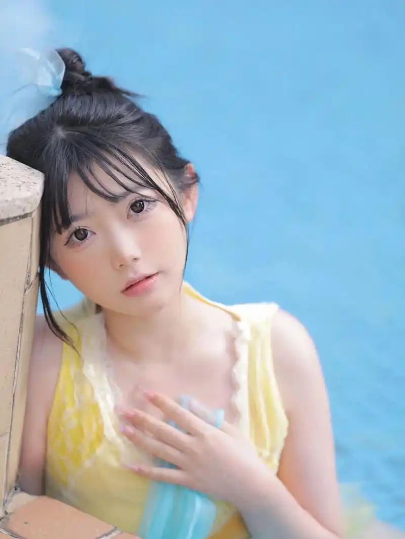 水中嬉戏玩耍的漂亮女孩,长相甜美可爱,淡黄色裙式泳装很漂亮