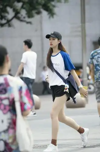 路人街拍:走路轻盈的小姐姐,黑色短裤秀出白色长腿,女人味十足