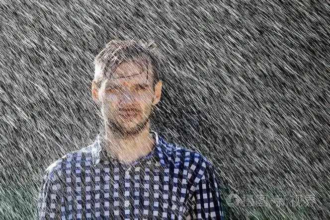 戴帽子的农夫正在享受雨夏天雨下的年轻人被淋湿了