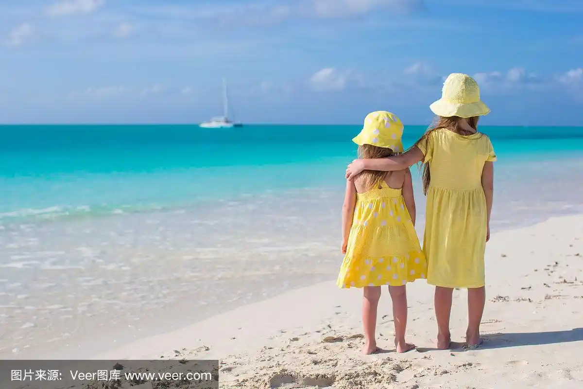 两个可爱的小女孩看着大海的背影