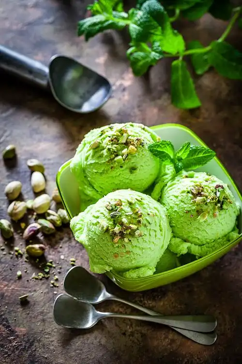 开心果冰淇淋在一个绿色的碗拍摄在花园的桌子上