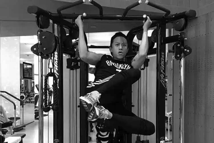 健身器材上摆出各种搞怪姿势,蹬腿侧踢,表情搞怪,双臂的肌肉相当抢眼