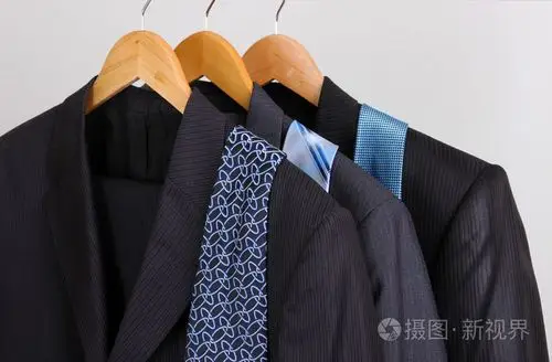 西装和领带挂在衣架上的灰色背景上