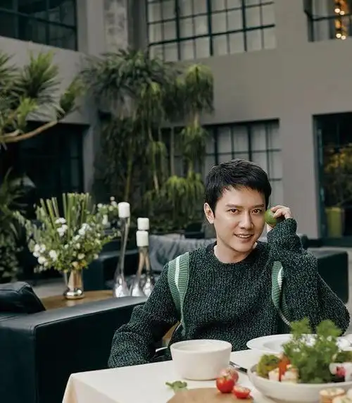 今日冯绍峰身着墨绿色的针织毛衣,穿搭与图中的景色相呼应,手拿柠檬