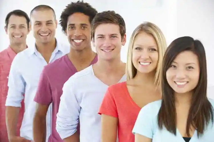 街头坐在滑板上微笑的爆炸头女性