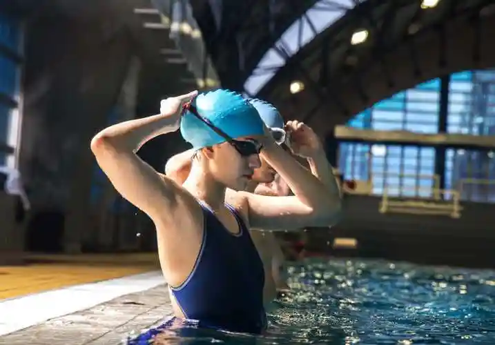 黑色背景下两名游泳运动员站在水里准备游泳