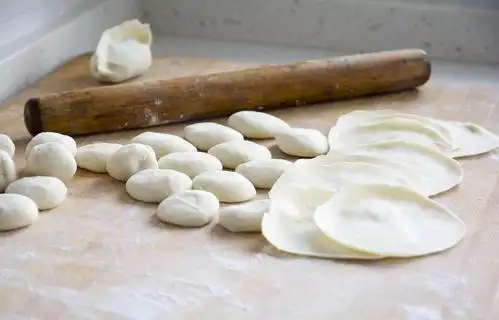 阿婆说擀饺子皮用力要均匀,使饺子皮的大小,厚度形状均匀一致,具体的