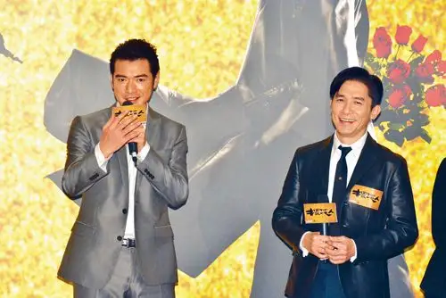 金城武与梁朝伟在台上谈笑风生.