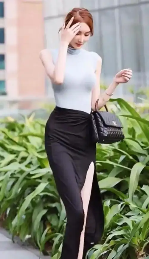 美女黑色的半身开叉裙行走在街上给人留下一个精致美女的画面