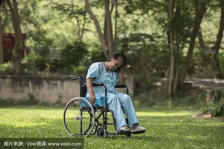 孤独的老人坐在轮椅上悲伤的感觉在医院的花园