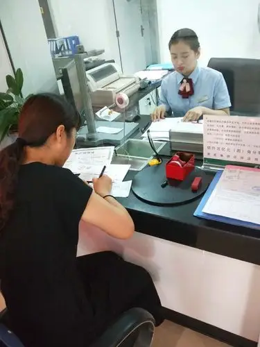 区社保办工作人员在银行办理被征地农民账户相关业务
