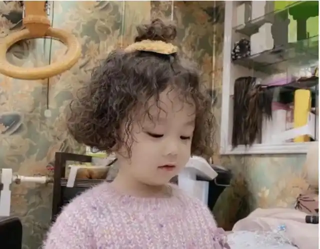 这位小女孩儿全头烫了羊毛卷,看起来时髦又可爱,白皙的皮肤搭配一丝丝