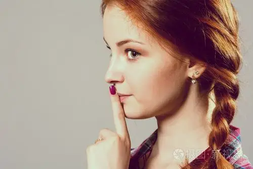 嘘— — 一个漂亮的女孩扎着辫子做 shushing 的手势