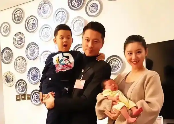 而李小萌则温柔地怀抱着小儿子,一家四口看起来温馨而幸福