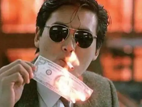 在《英雄本色》中,他拿着钱点烟的动作被称之为经典.