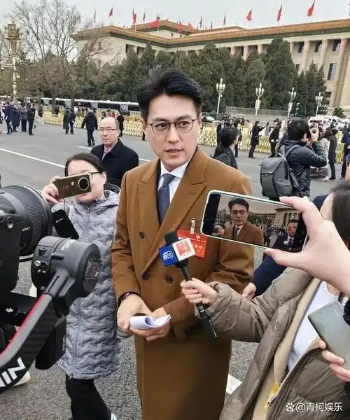 他身着棕色大衣,配戴着黑框眼镜,显得文质彬彬.