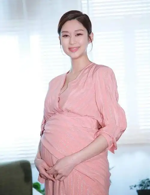 岑丽香肚大如箩粉裙显温柔 孕期踩高跟鞋工作超拼