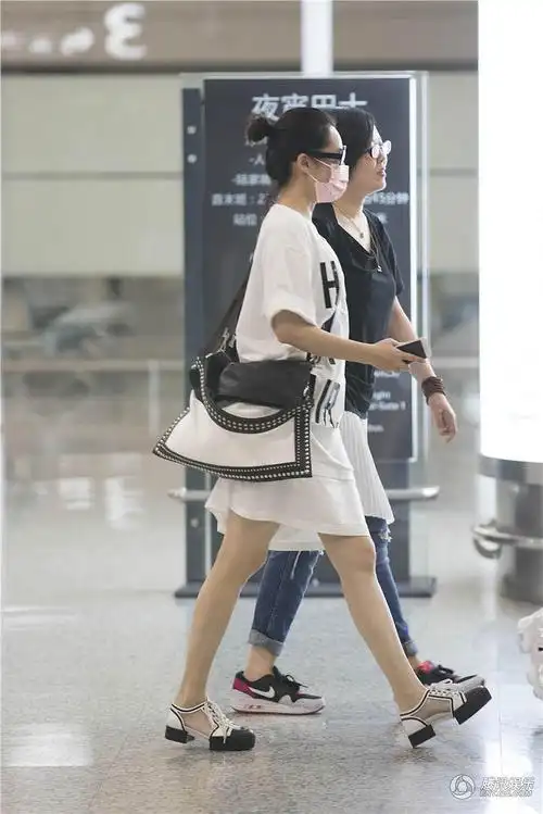 许晴现身机场懒理花少风波 与助理搭肩笑弯腰