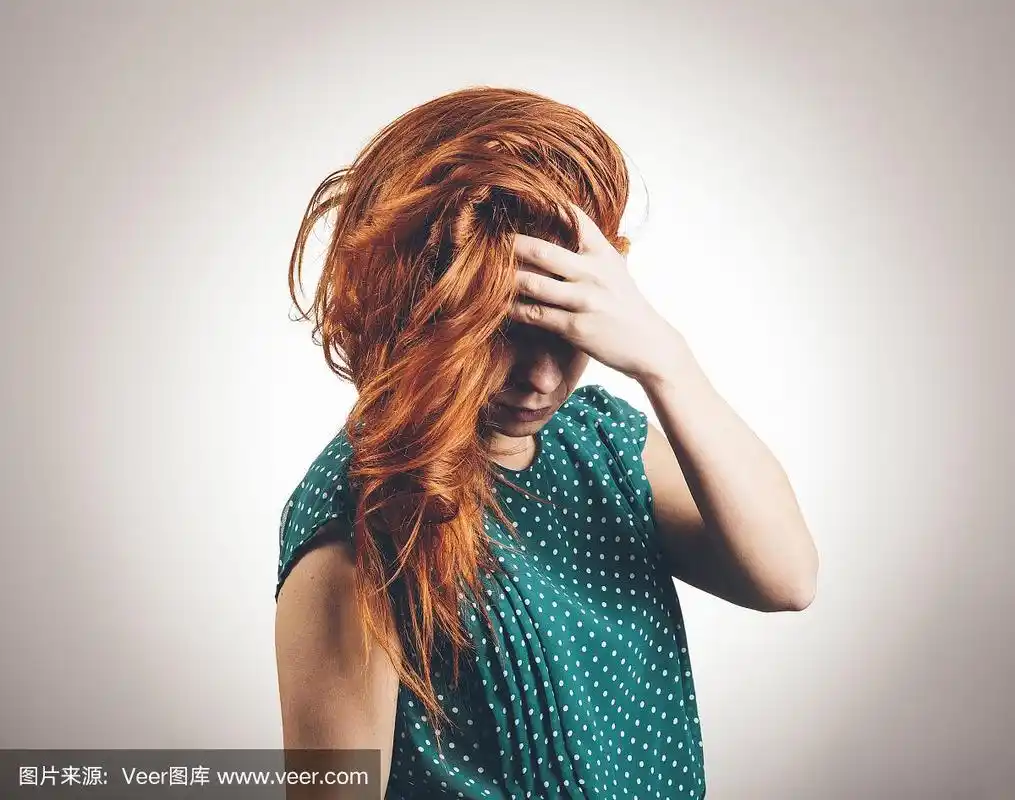 悲伤的年轻女人低头遮住眼睛