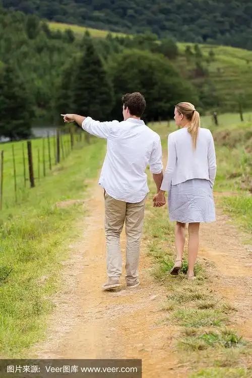 一对年轻夫妇走在乡间小路上