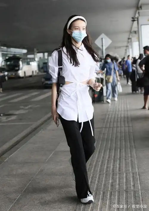 女演员金晨现身机场,穿镂空露腰衬衣开叉裤,踩老爹鞋十分精致