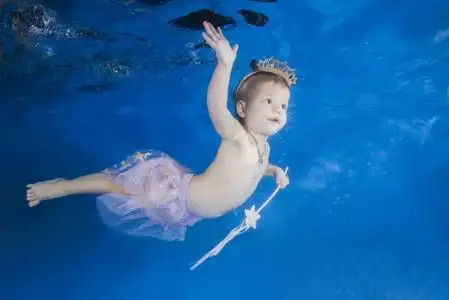健康之家拿着魔杖在水下游泳的小女孩.健康之家照片