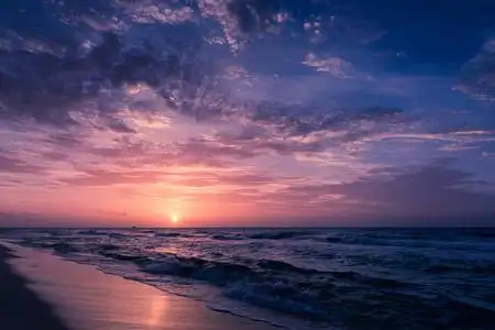 夏日海滩与蓝色的海水和紫色的天空照片