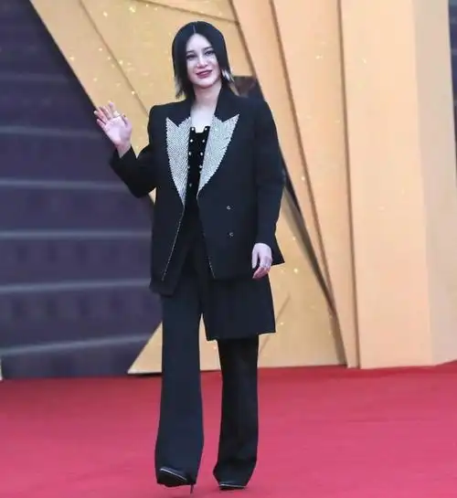 尚雯婕上身穿了一件燕尾风格的衬衣,下身搭配黑色裤子,脚踩黑色靴子